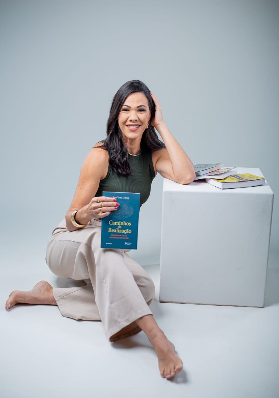 Tatiana Ferreira Natal segurando o livro Caminhos da Realização